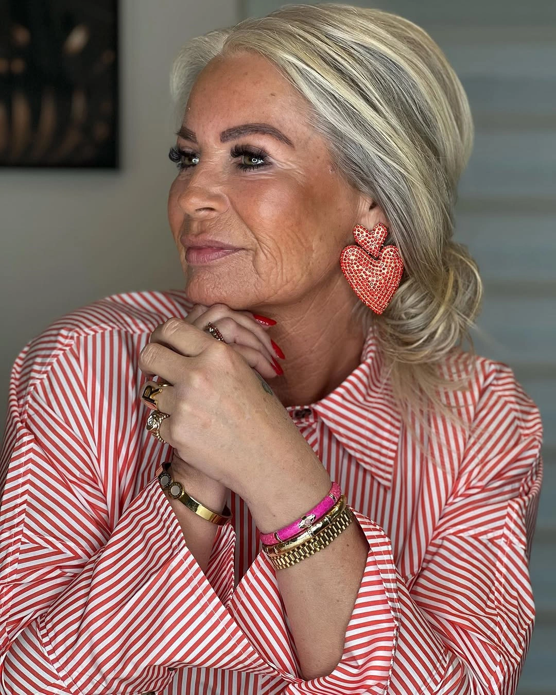 Blonde side-swept gathered hair with loose curled nape pieces