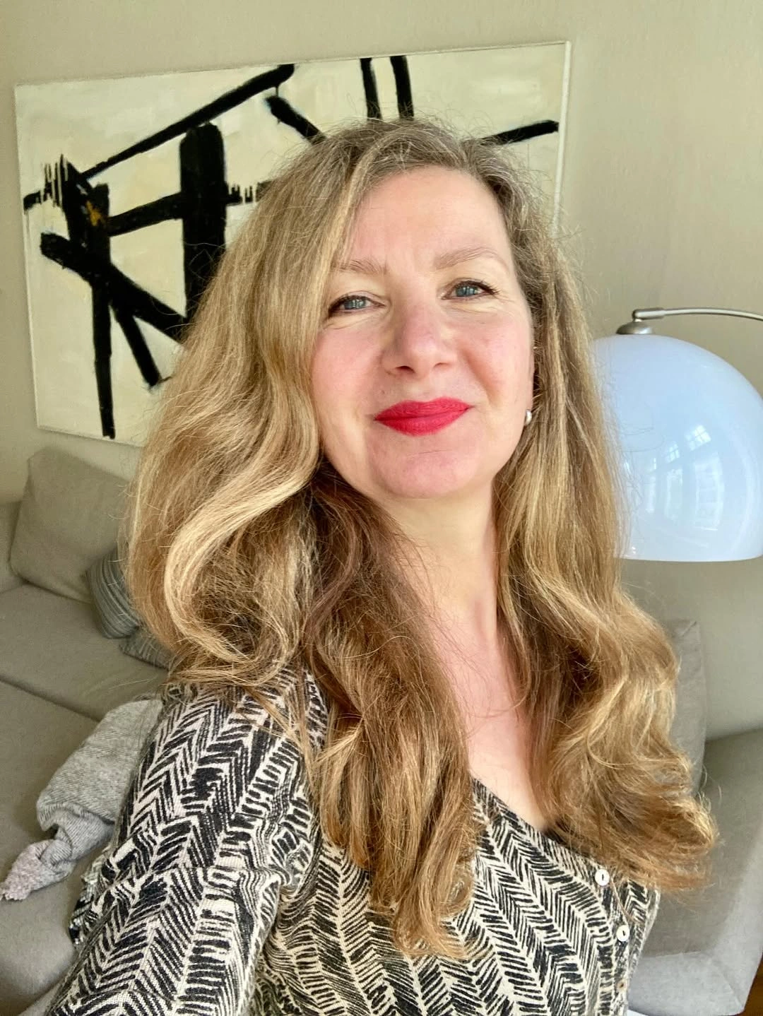 Long warm blonde waves with center part and cascading bends