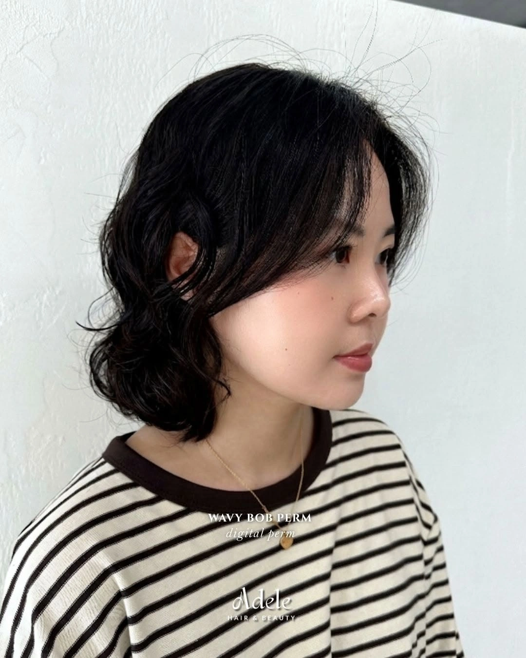 Short dark wavy bob-like hairstyle with side opening