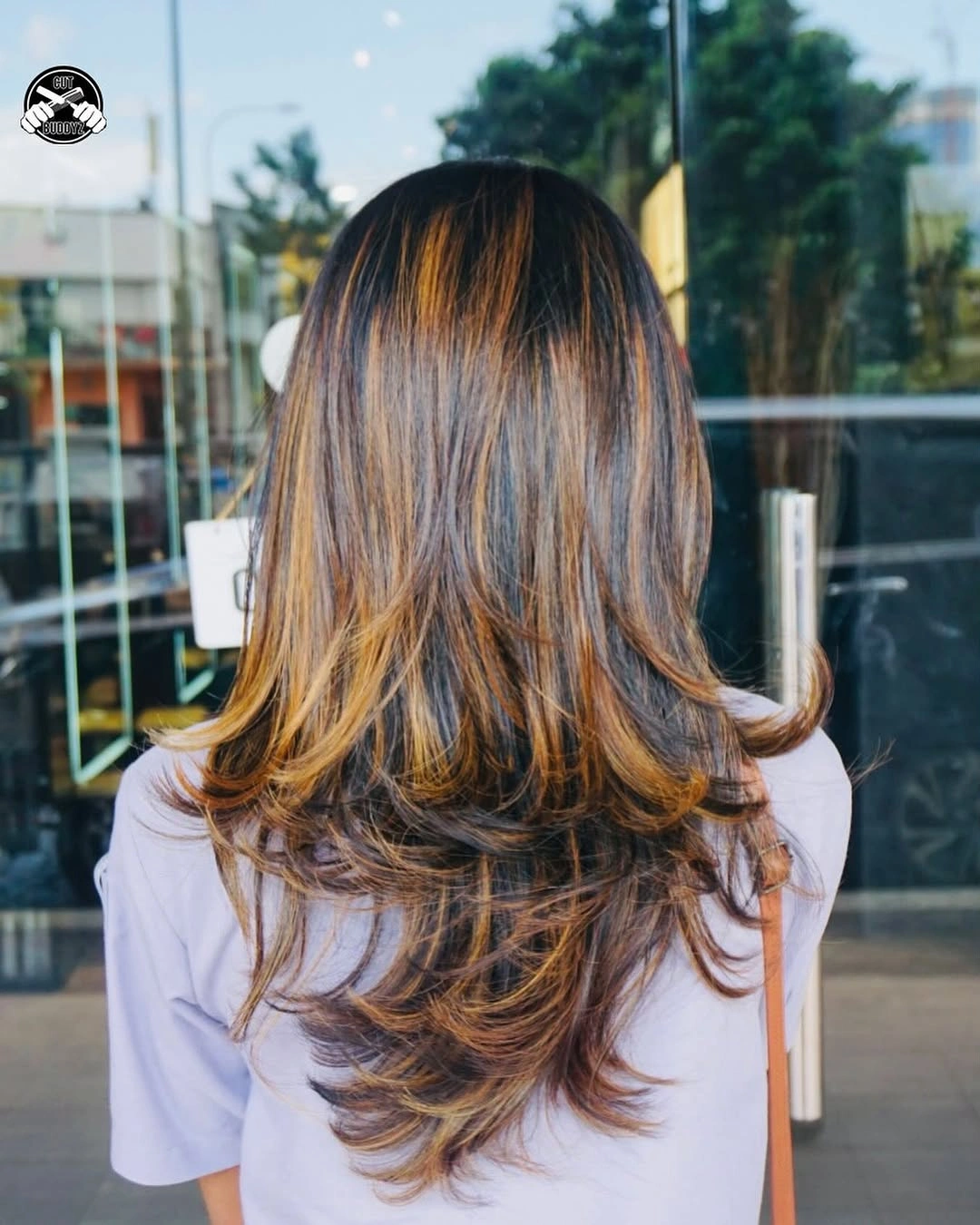 Long layered brunette hair with caramel ribbons and flipped ends