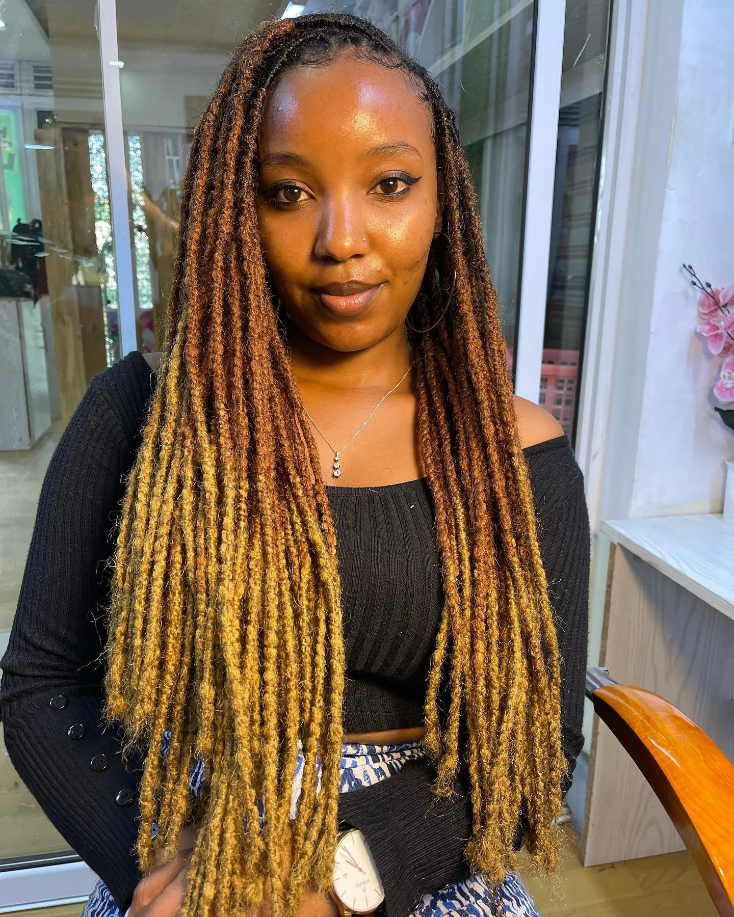 Long narrow braids with golden-brown lengths over shoulders