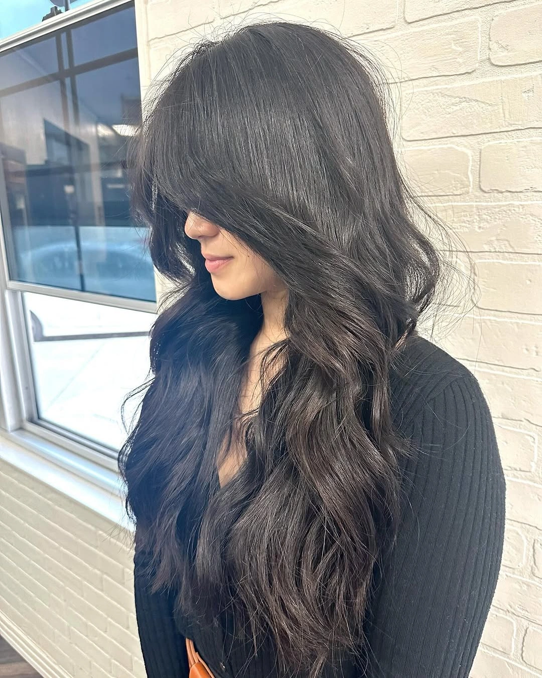 Very long dark wavy hair with glossy side-forward placement