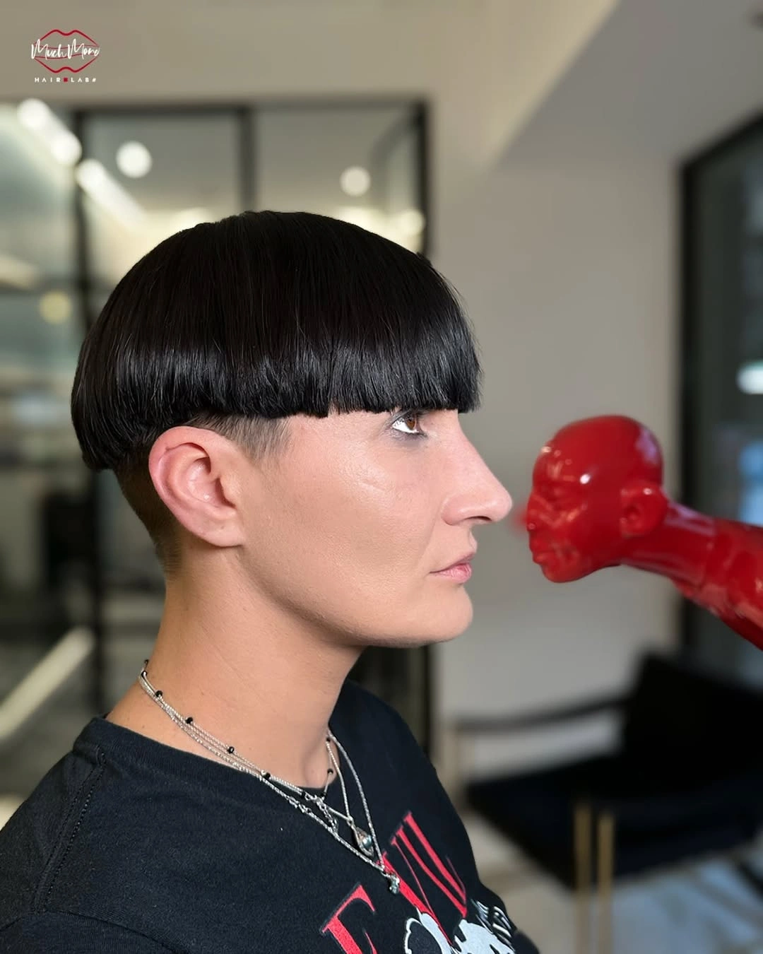 Short black cropped hairstyle with blunt curved fringe