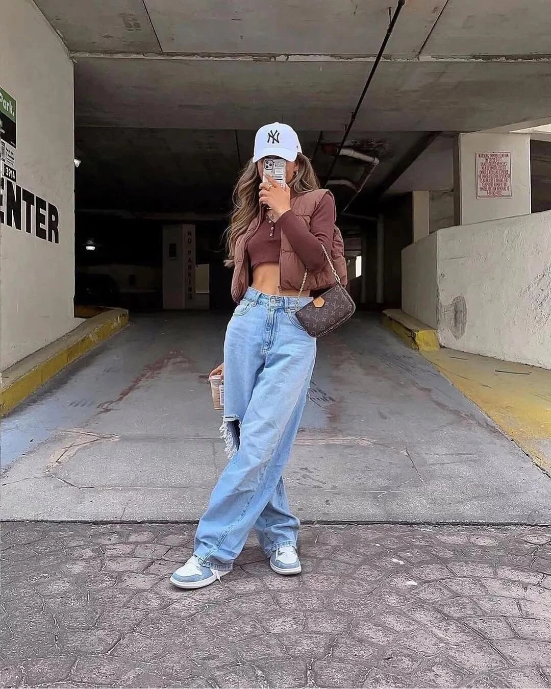 Brown cropped top with loose ripped jeans and white cap