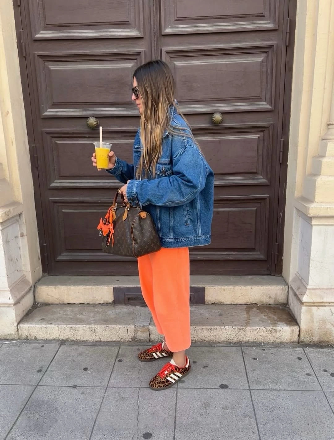 Oversized denim jacket with bright orange lower piece and printed flats