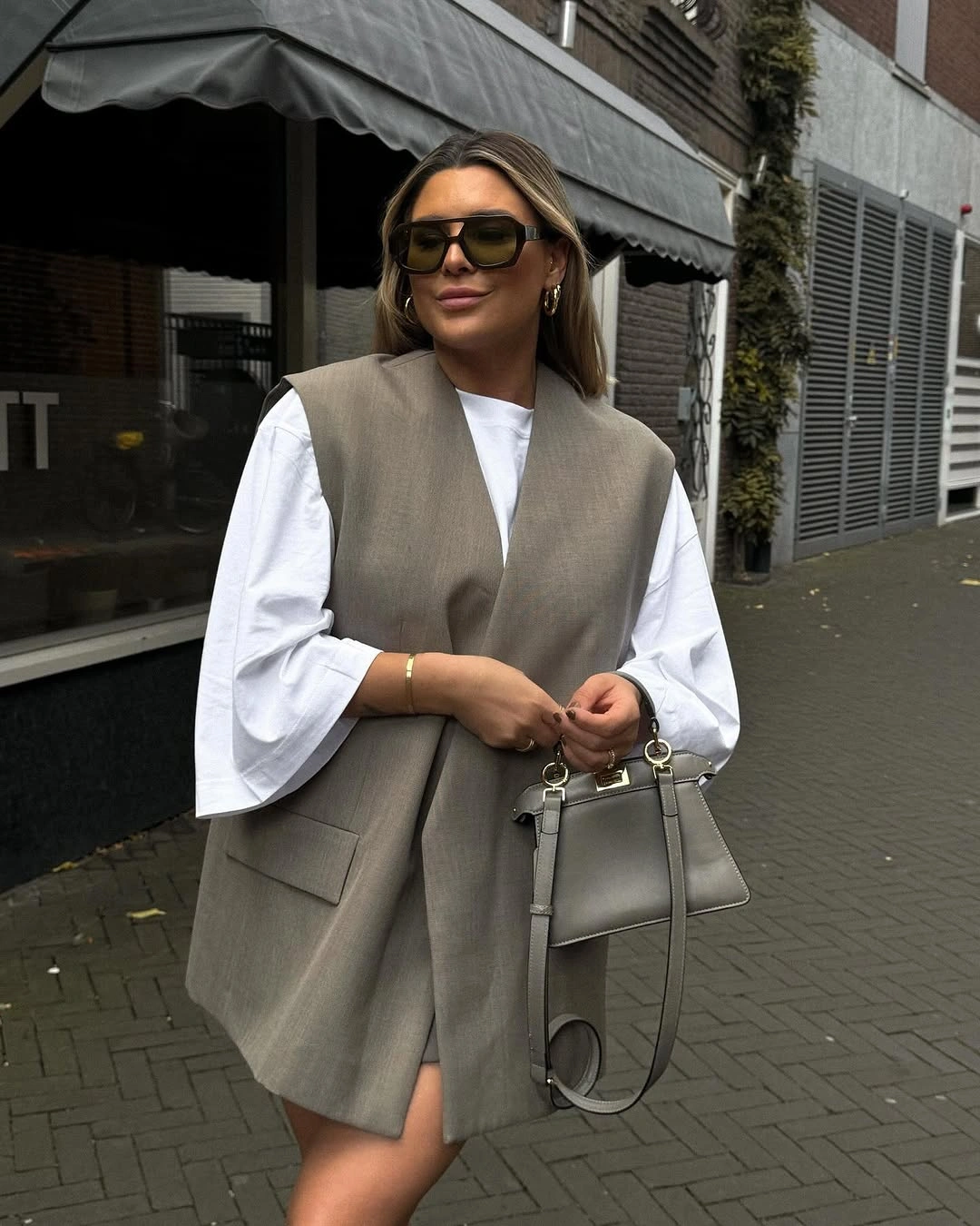 Long gray sleeveless vest over white wide-sleeve top