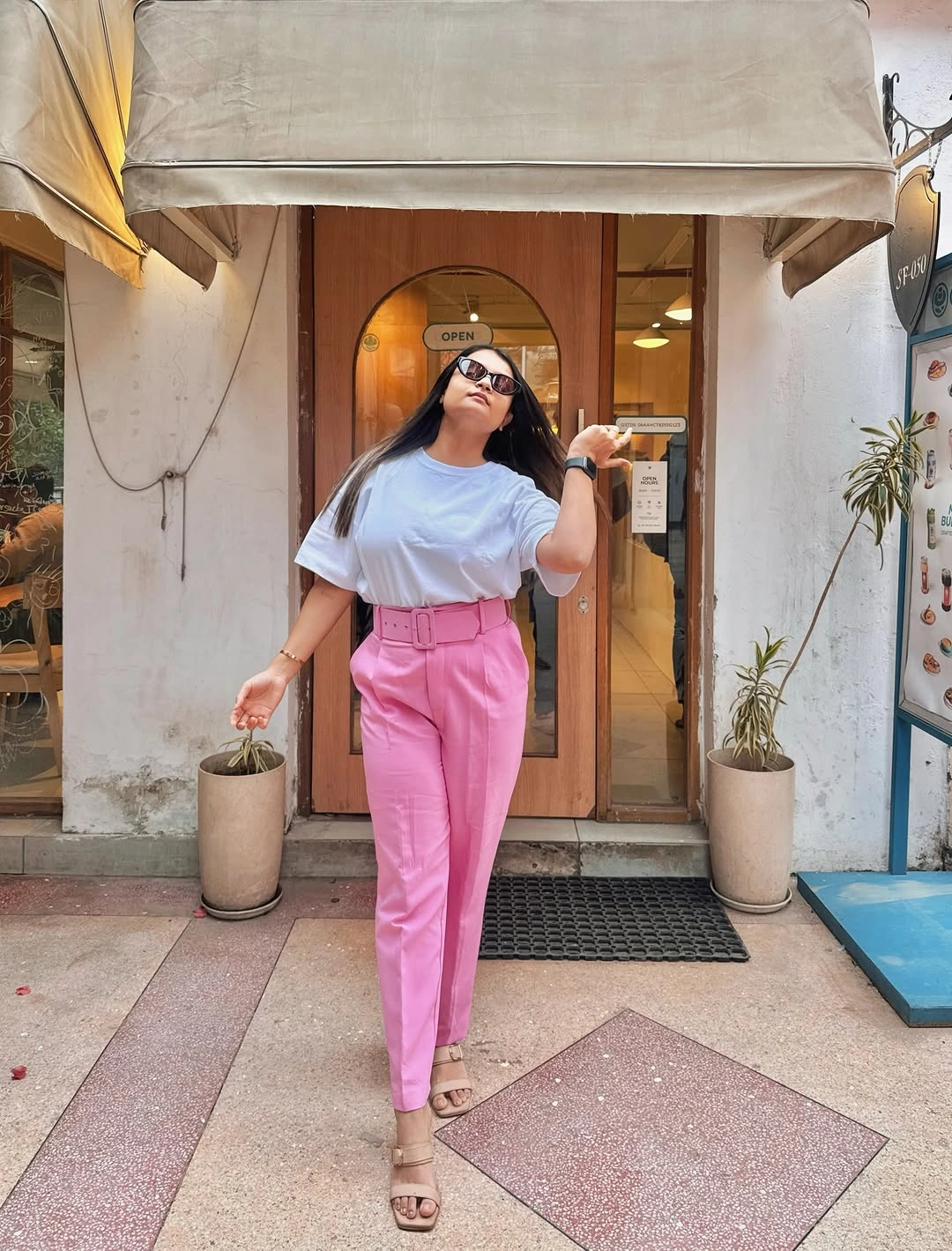 White T-shirt tucked into belted bright pink trousers