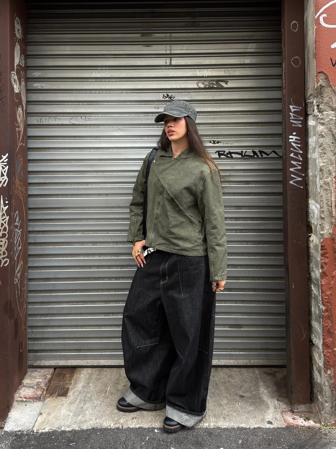 Gray cap with green diagonal top and very wide dark trousers