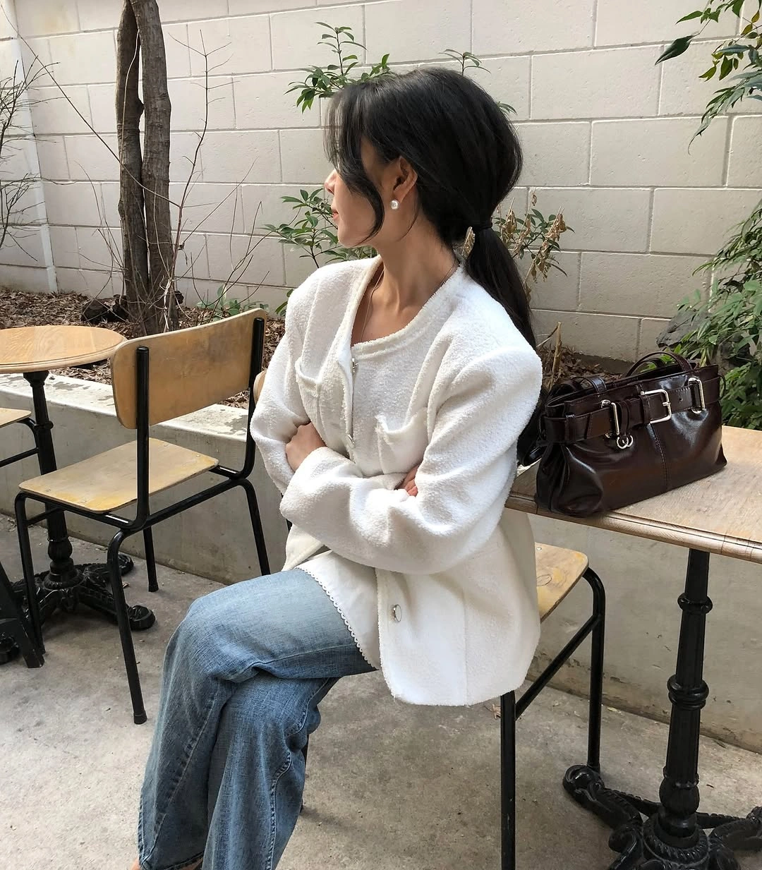 Soft white textured cardigan with flared blue jeans