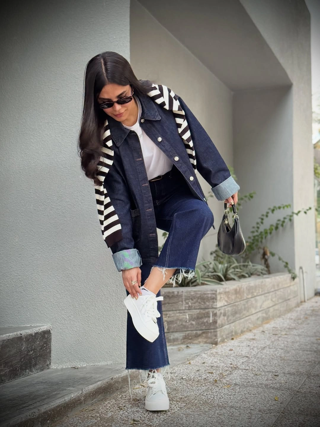 Dark denim jacket, white T-shirt, striped shoulder layer and sneakers