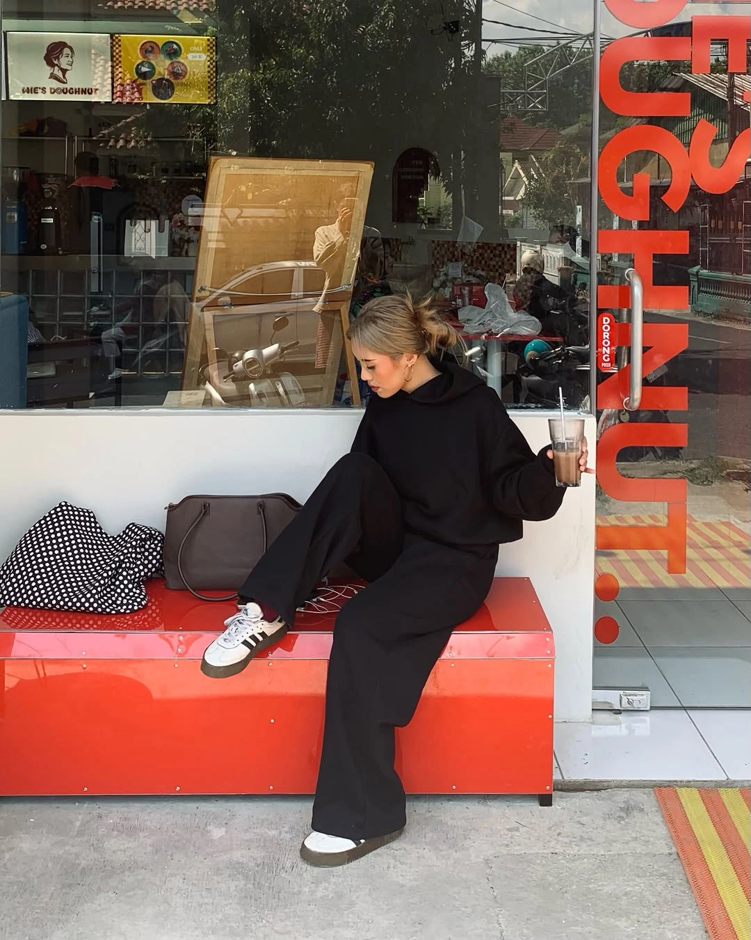 Black hoodie, loose black trousers, sneakers and dark bag