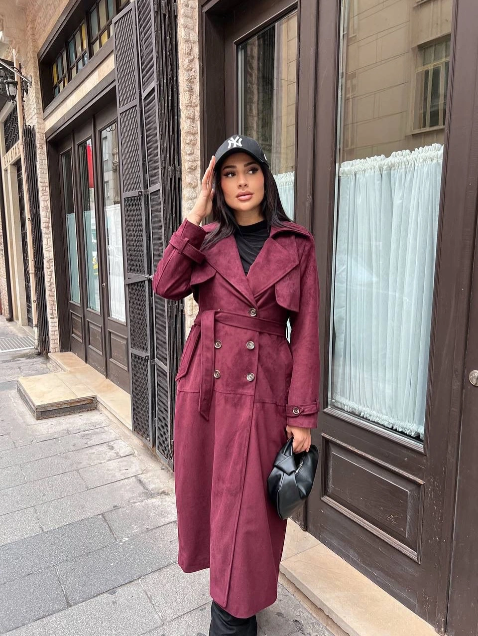 Burgundy belted coat with black cap, boots and bag