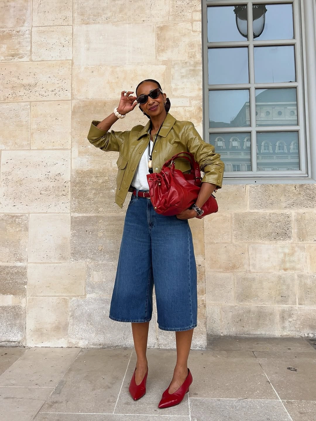 Olive jacket with wide knee-length denim and red pointed shoes