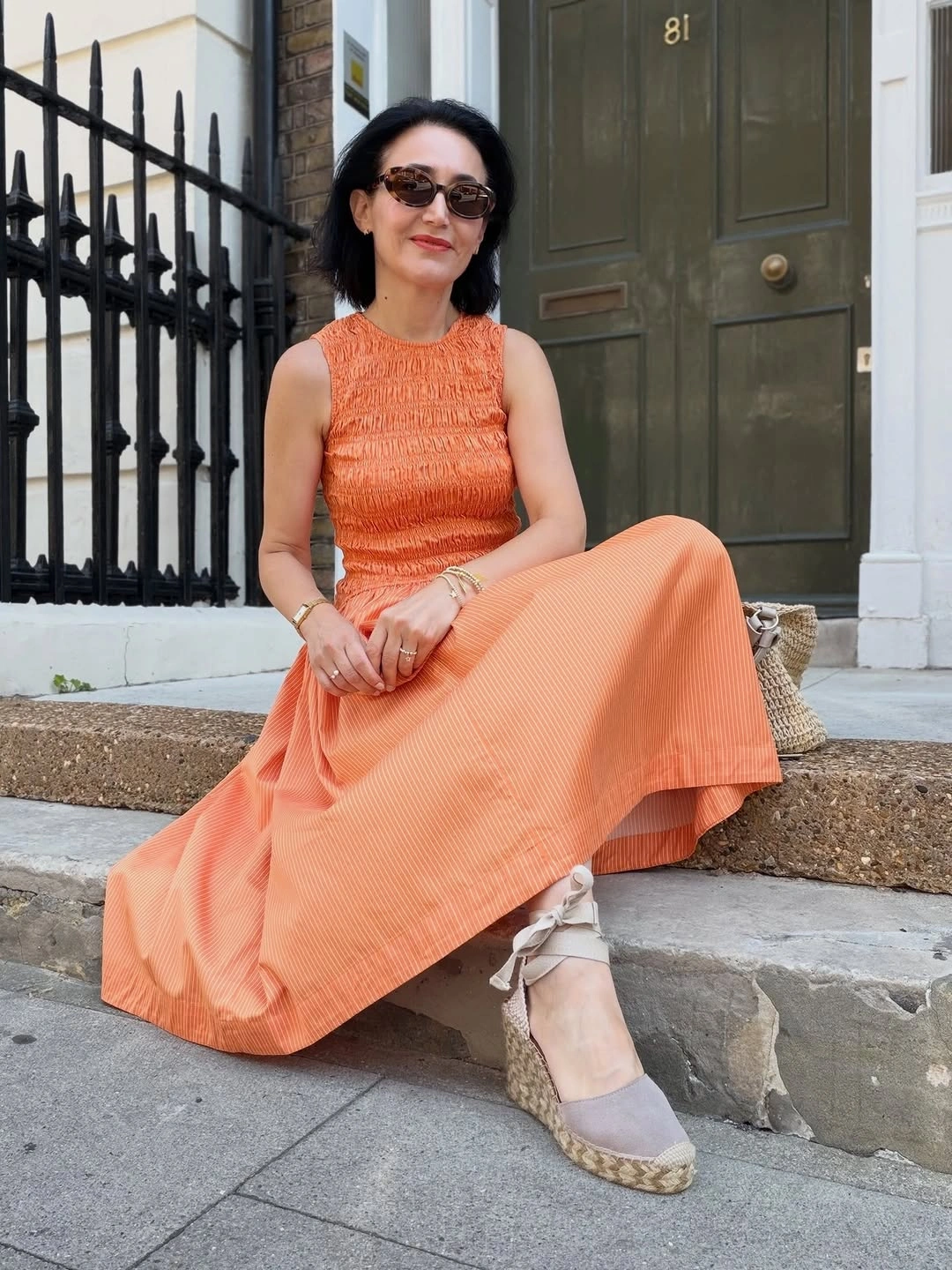 Tonal orange sleeveless outfit with espadrille wedges and woven bag