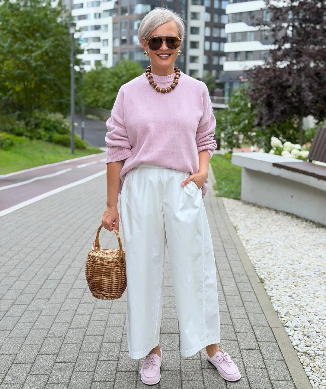 Pale pink sweater with white cropped trousers and pink sneakers