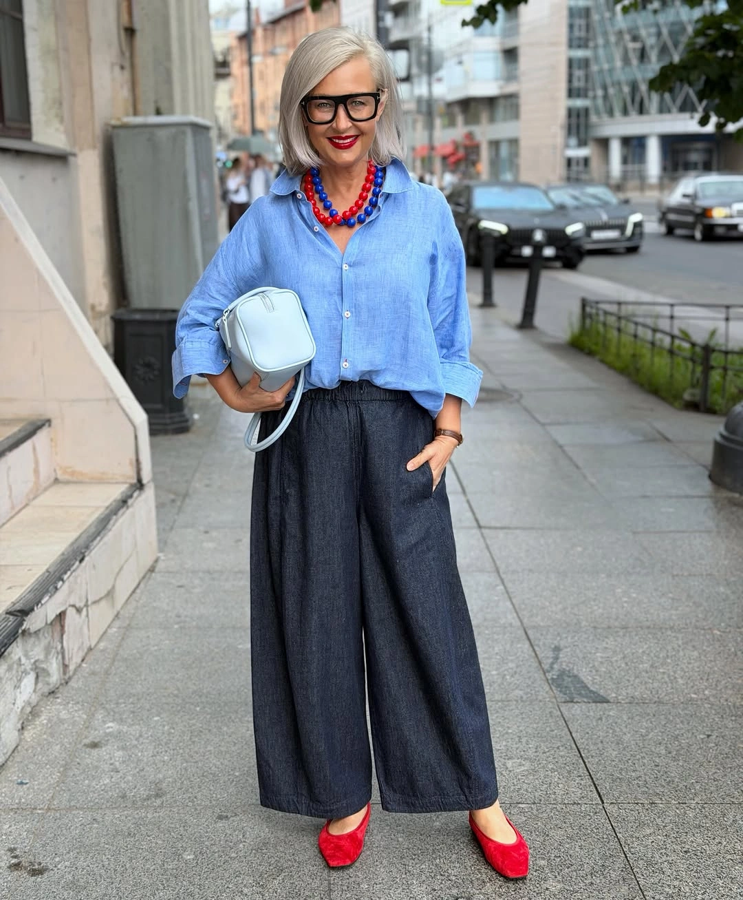 Light blue shirt with wide dark trousers and red flats