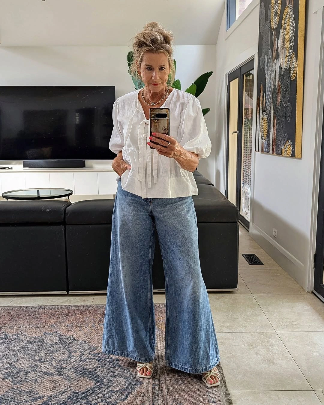 White tie-front blouse with wide blue jeans and sandals