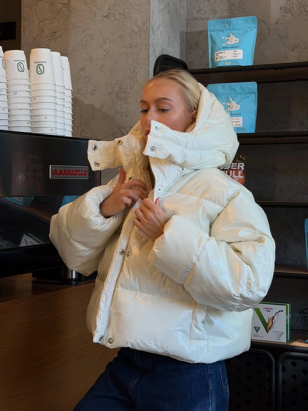 White oversized puffer with high collar and dark jeans