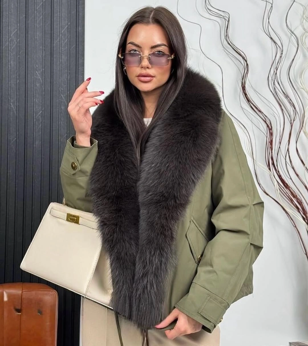 Olive outerwear with dark plush-looking collar and pale handbag