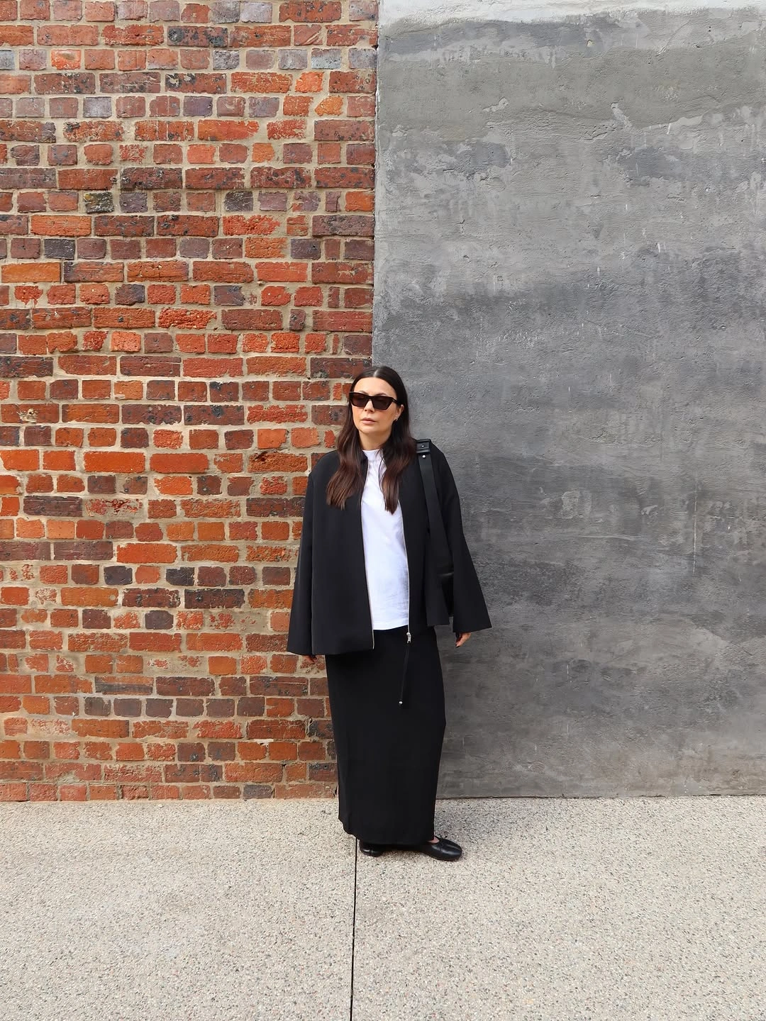 Black cropped coat, white top and wide black trousers