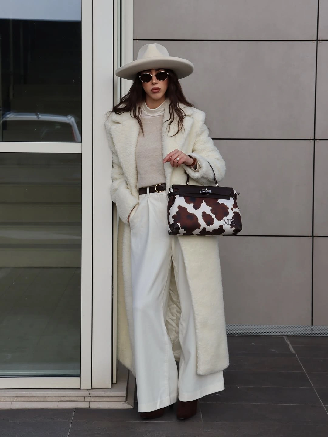 Cream long coat with white trousers, hat and patterned bag