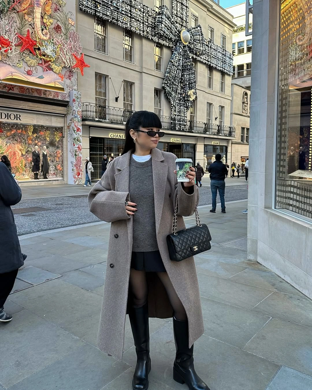 Gray coat and knit with black skirt and knee boots