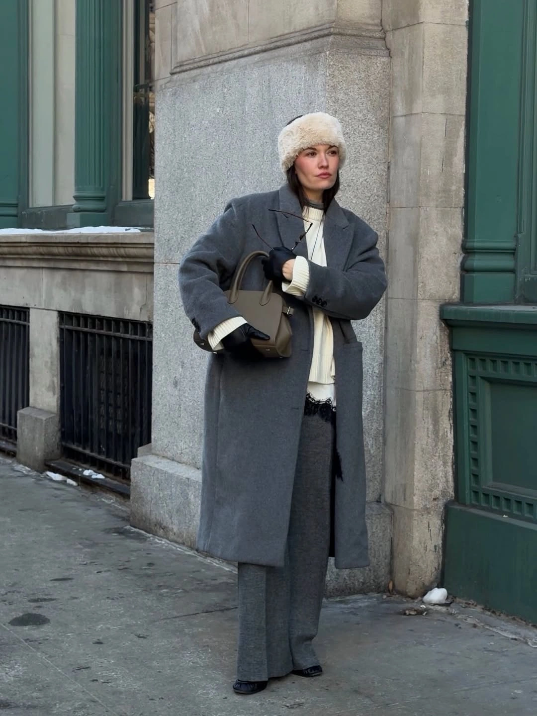 Gray coat and wide trousers with cream beanie and handbag