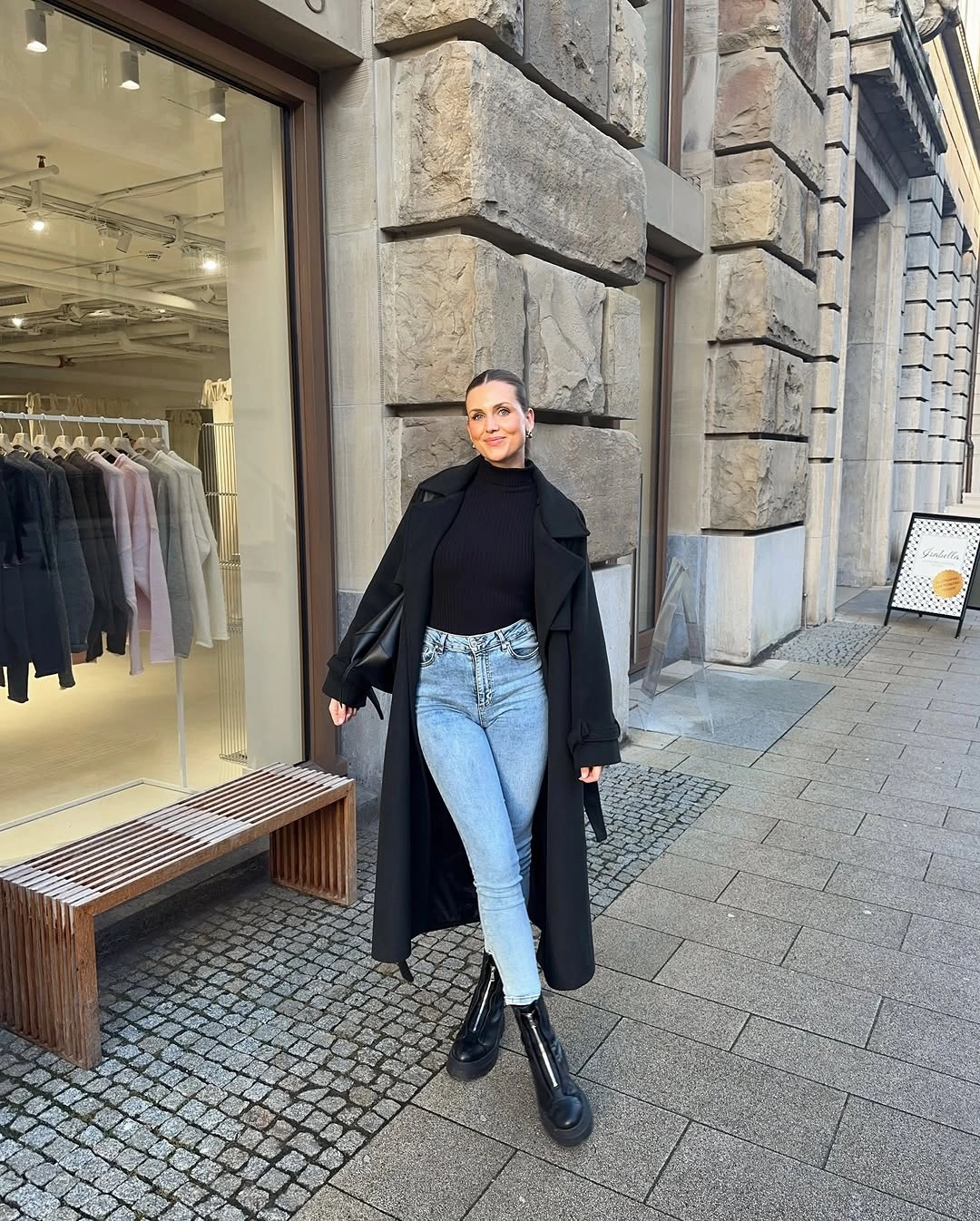 Black coat and knit with light blue jeans and boots