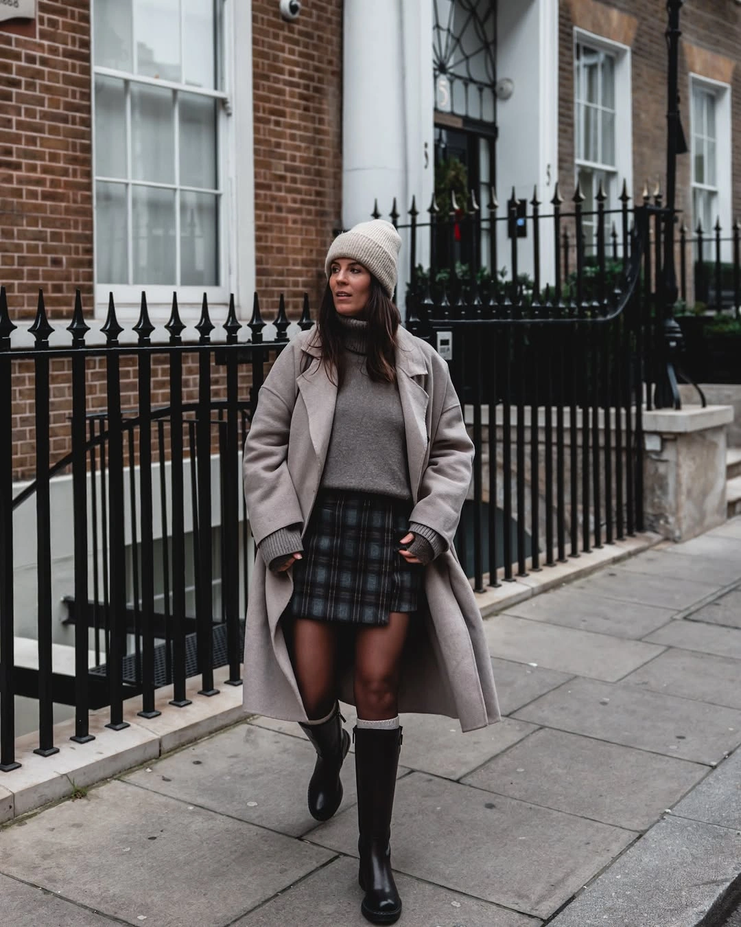 Gray coat and knit with plaid skirt and knee-high boots