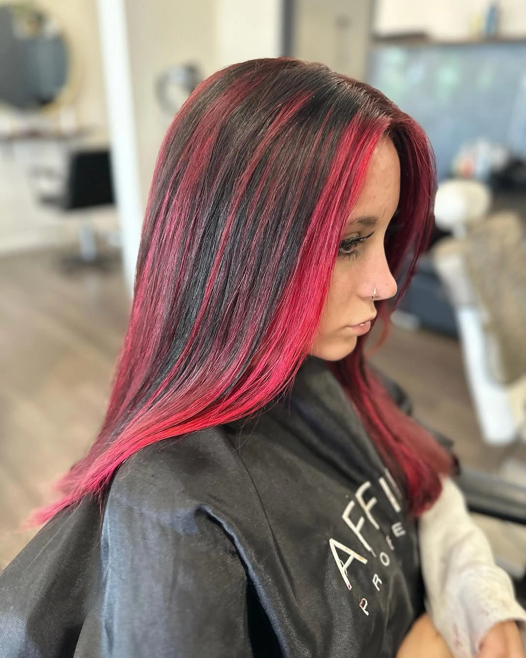 Straight charcoal hair with vivid pink magenta panels and center part