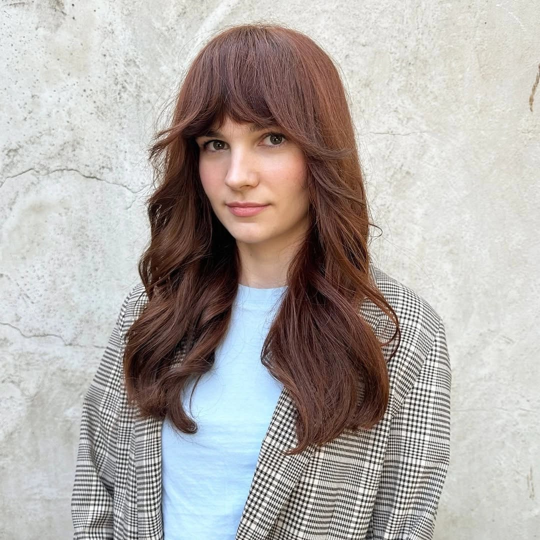 Long reddish-brown waves with copper and chestnut variation and a full airy fringe