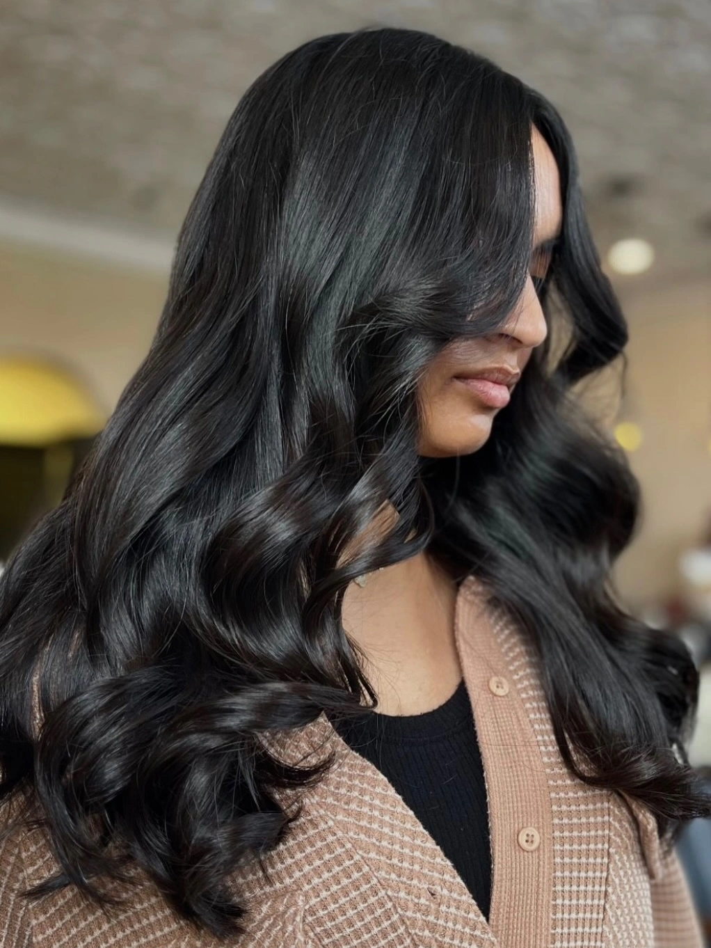 Long dark glossy hair with broad waves and faint blue green reflections