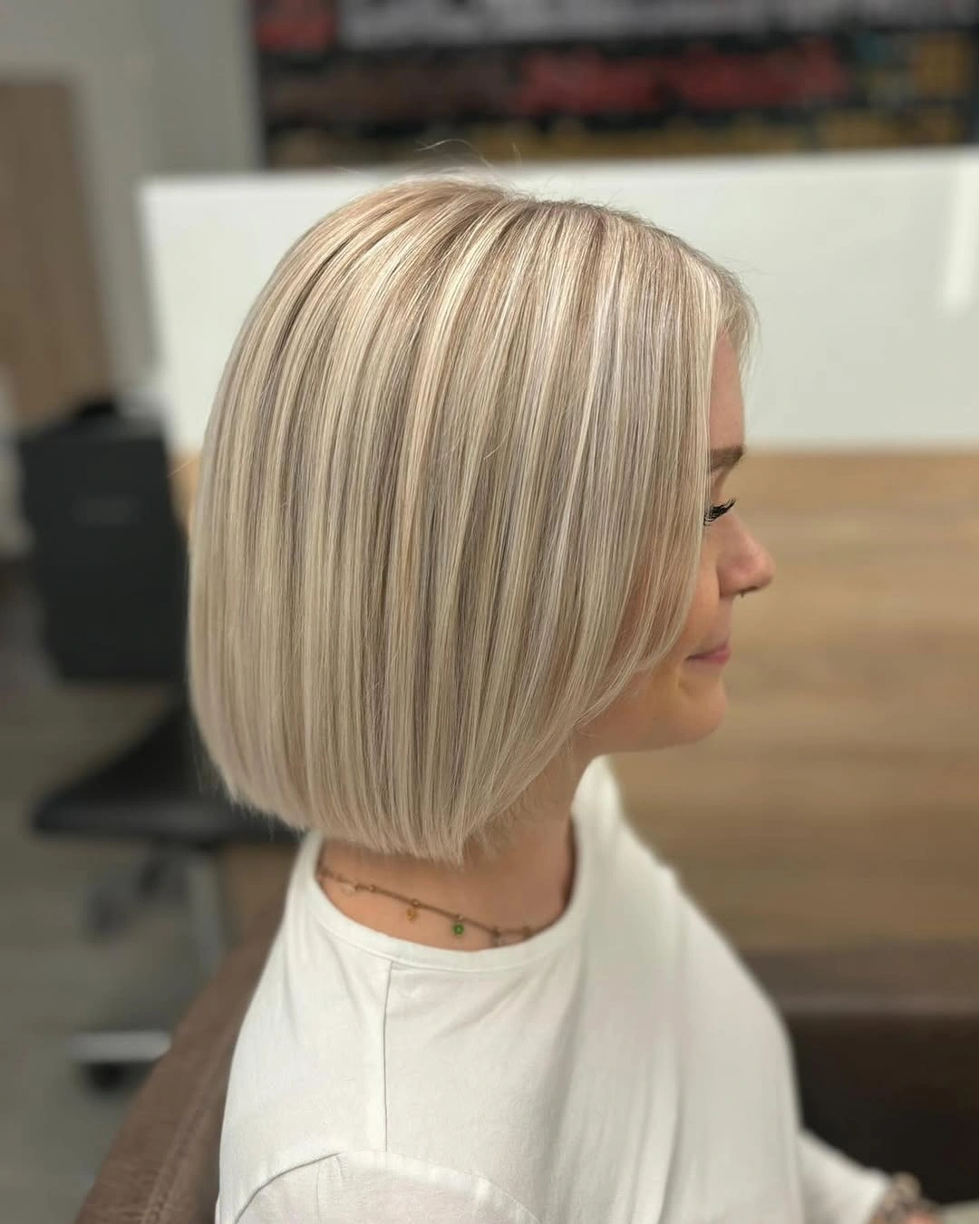 Rounded beige ash blonde bob with subtle root depth