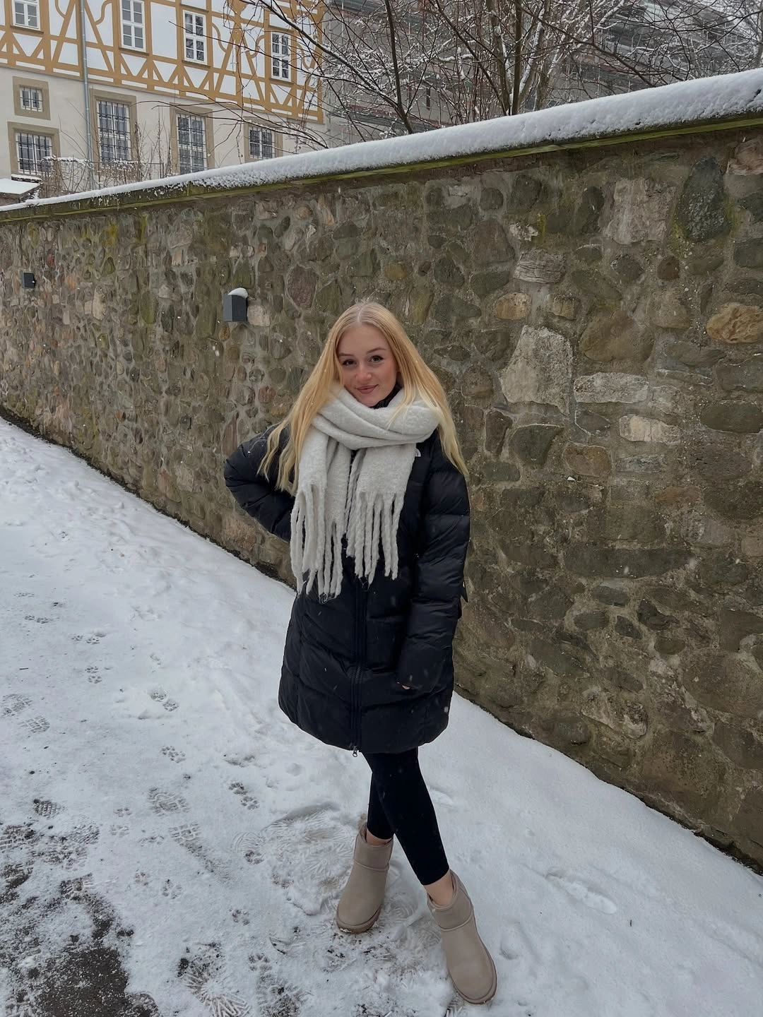 Black coat with cream scarf and pale ankle boots