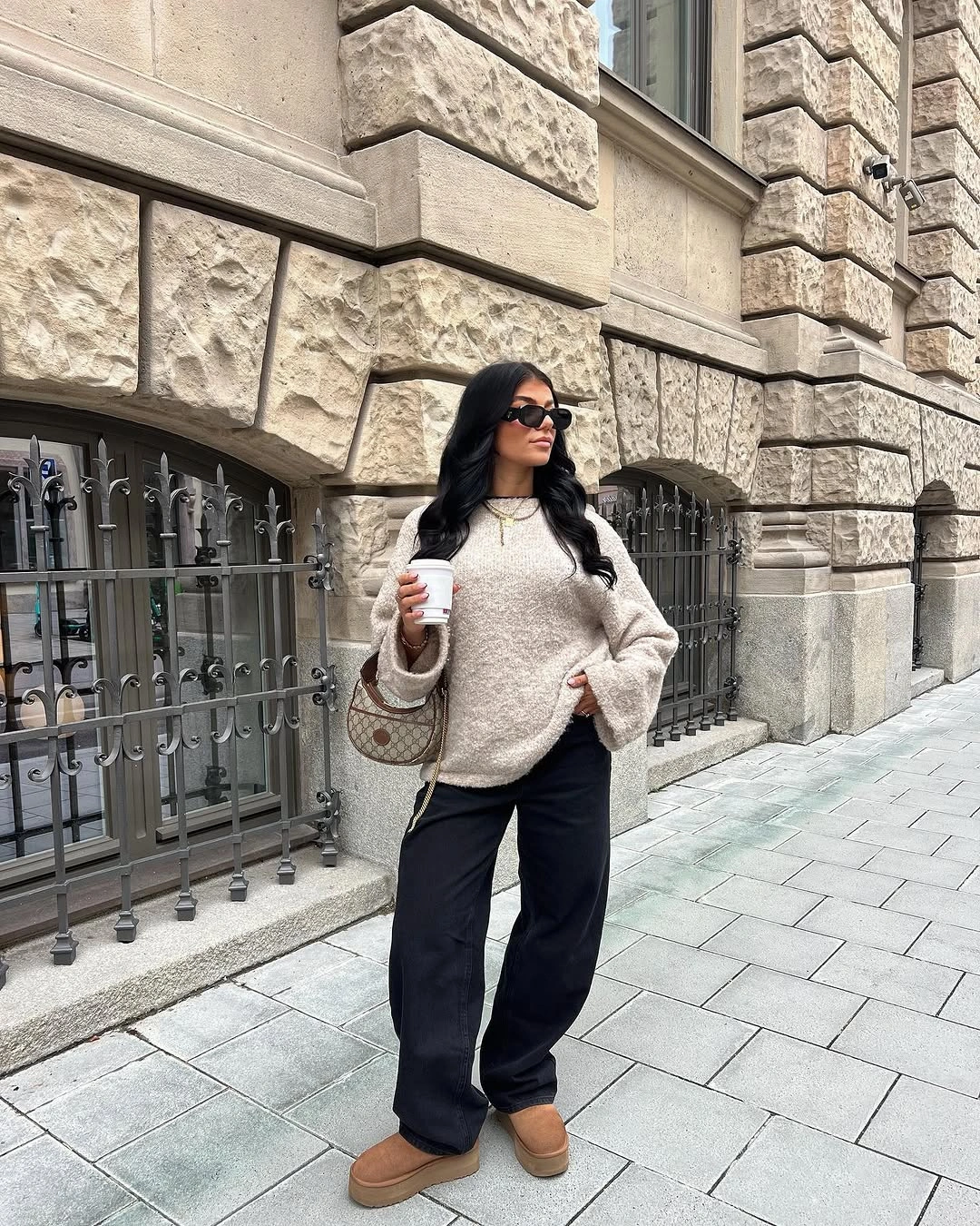 Pale textured sweater with black wide trousers and tan boots
