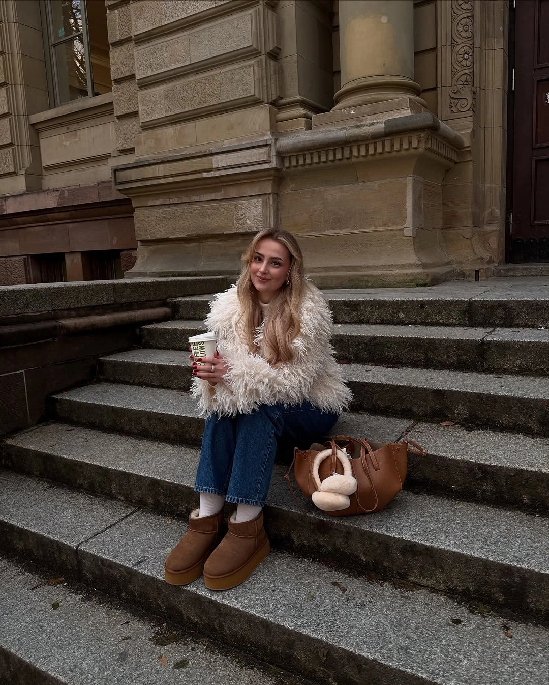 Cream fluffy cropped jacket with blue jeans and tan boots