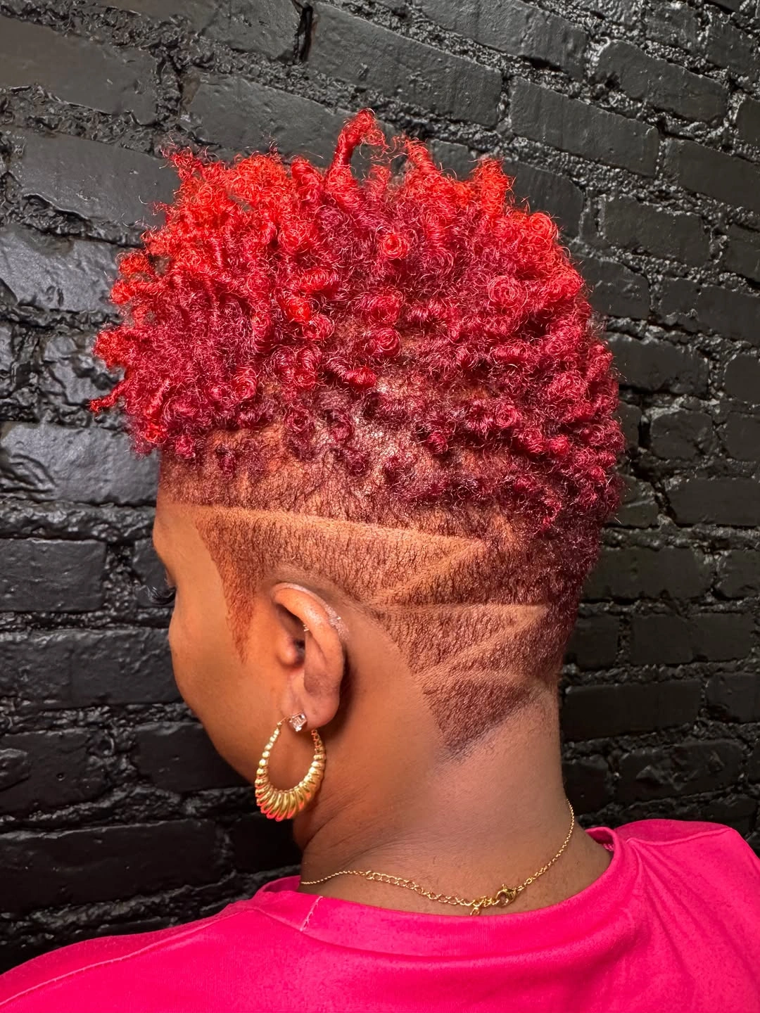 Bright red textured short hair with shaved side line designs