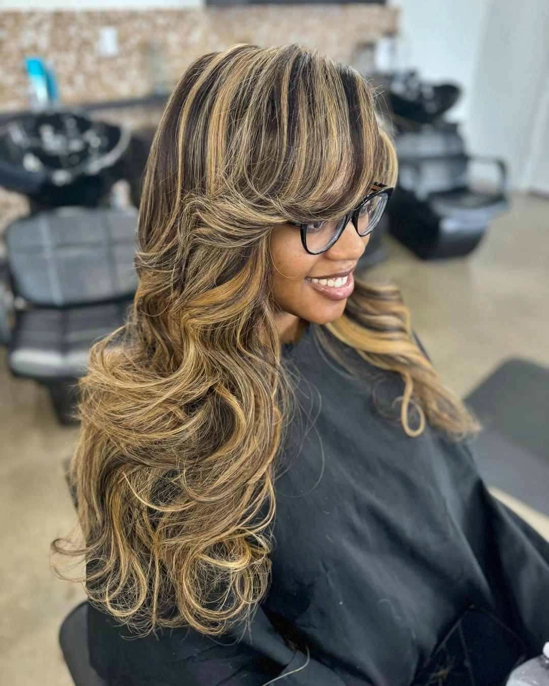 Long wavy hair with dark base and beige blonde highlights