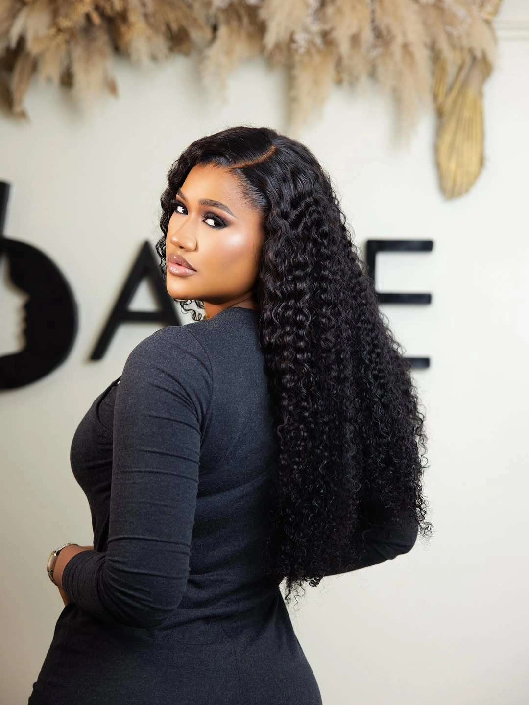 Long dense black curls with side part and half-up section