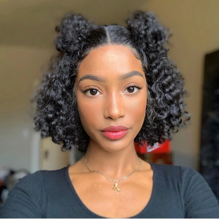 Dark curls in two high puffs with center part