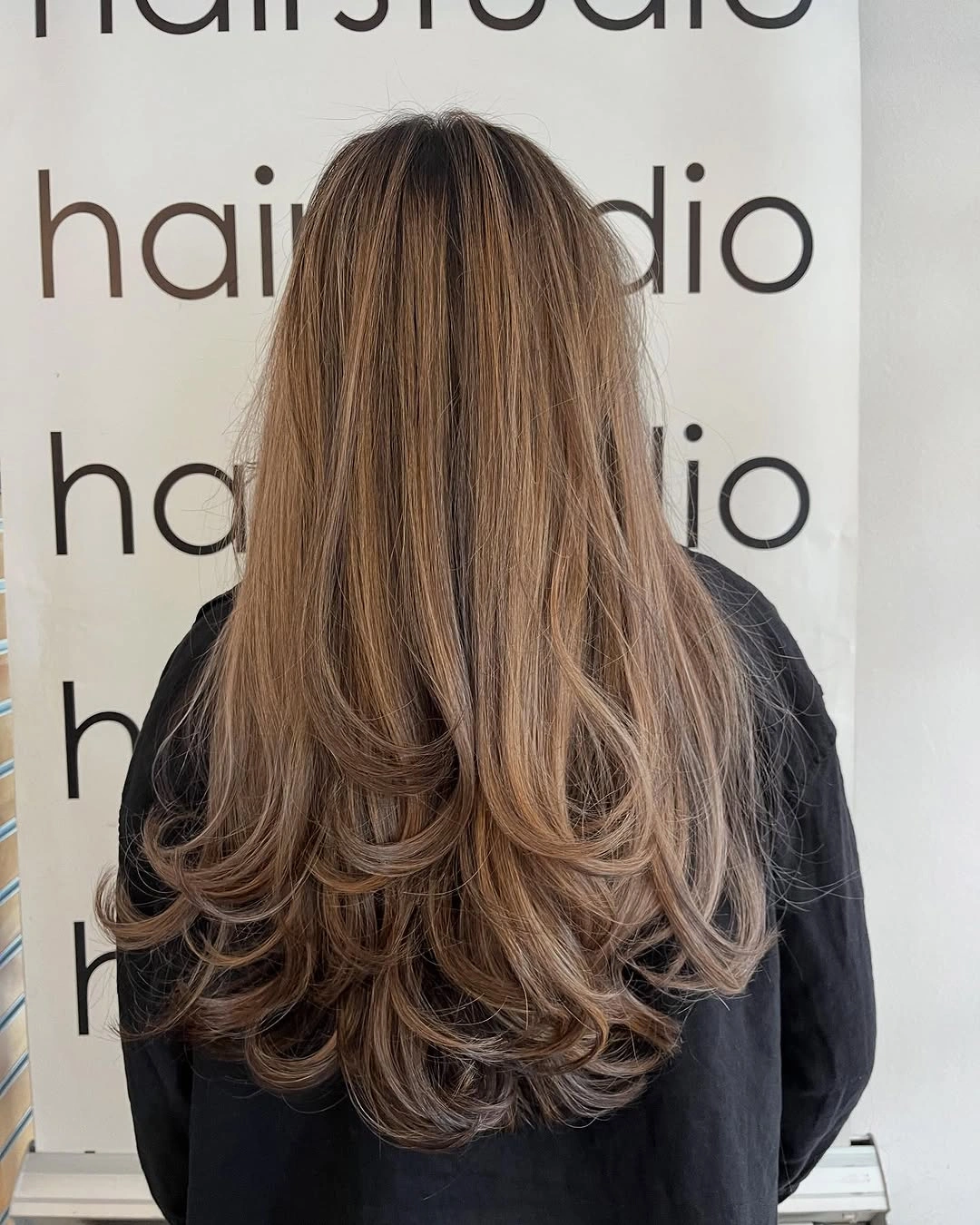 Long medium brown hair with caramel ribbons and curled layered ends