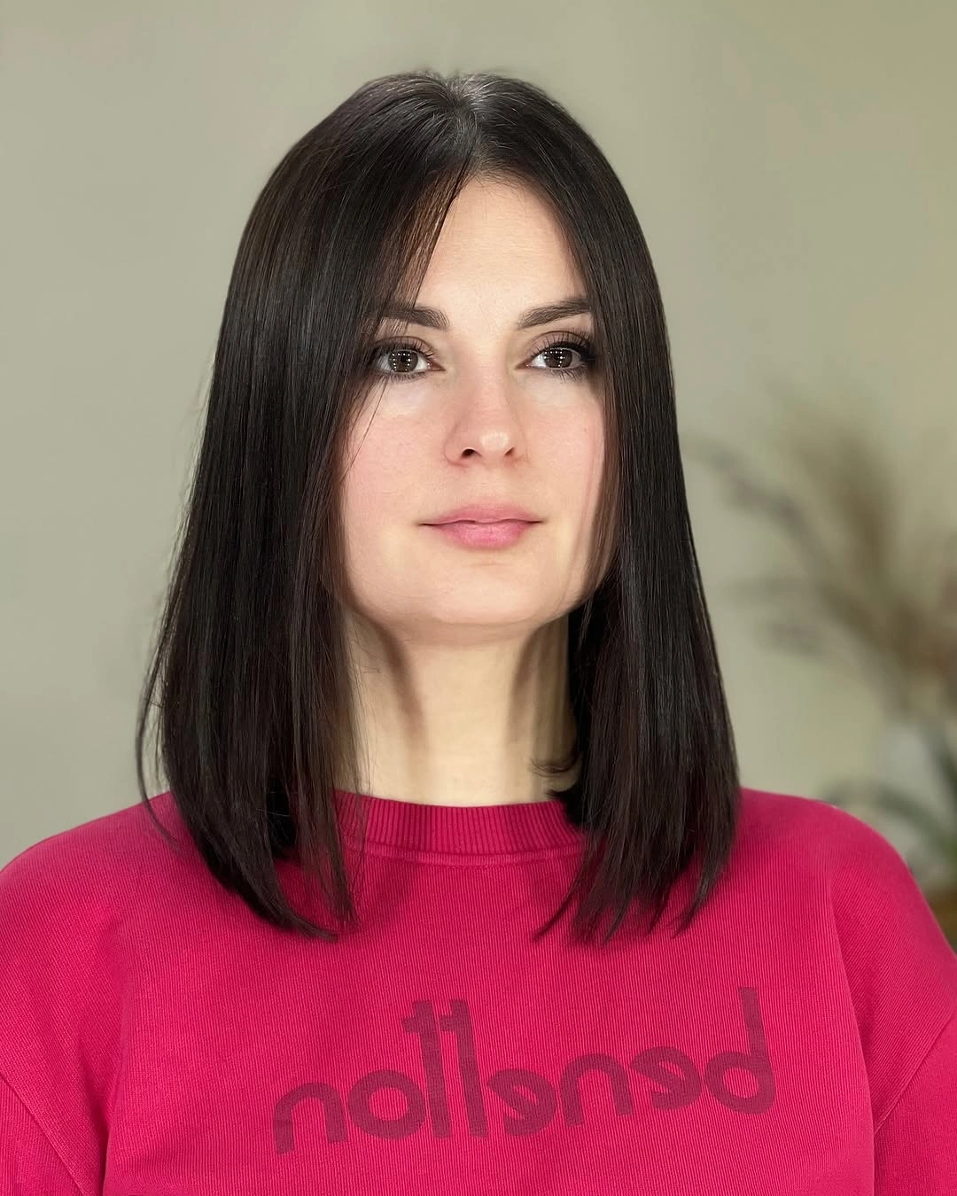 Straight dark shoulder length haircut with a center part