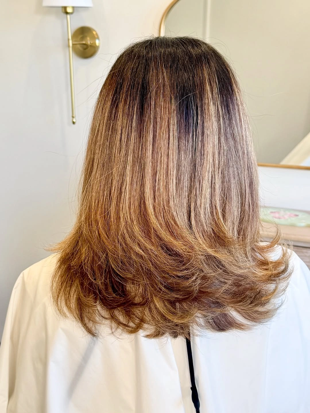 Warm brown feathered mid length haircut