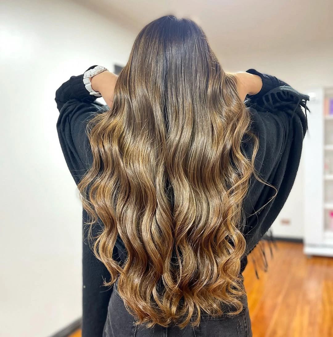 Long warm brown hair styled in loose waves from the back