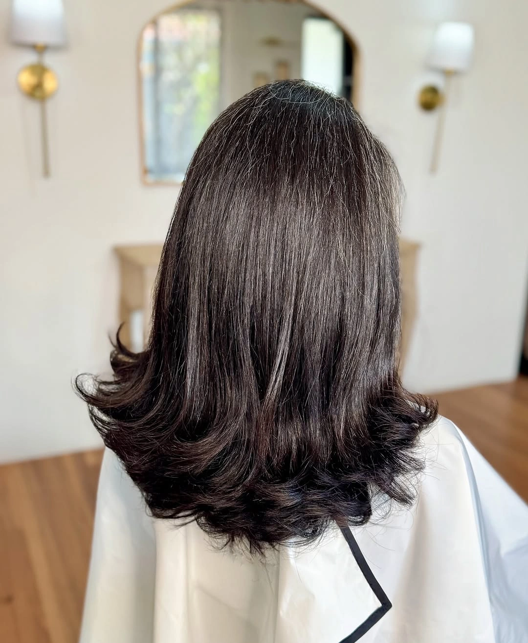 Shoulder length dark layered haircut with flicked ends