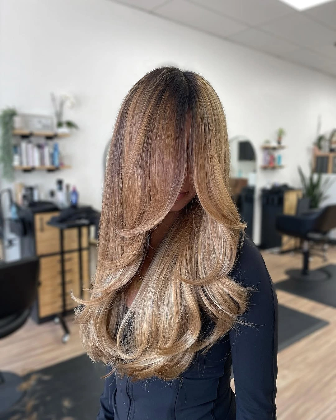 Long blonde layered haircut with curtain framed waves