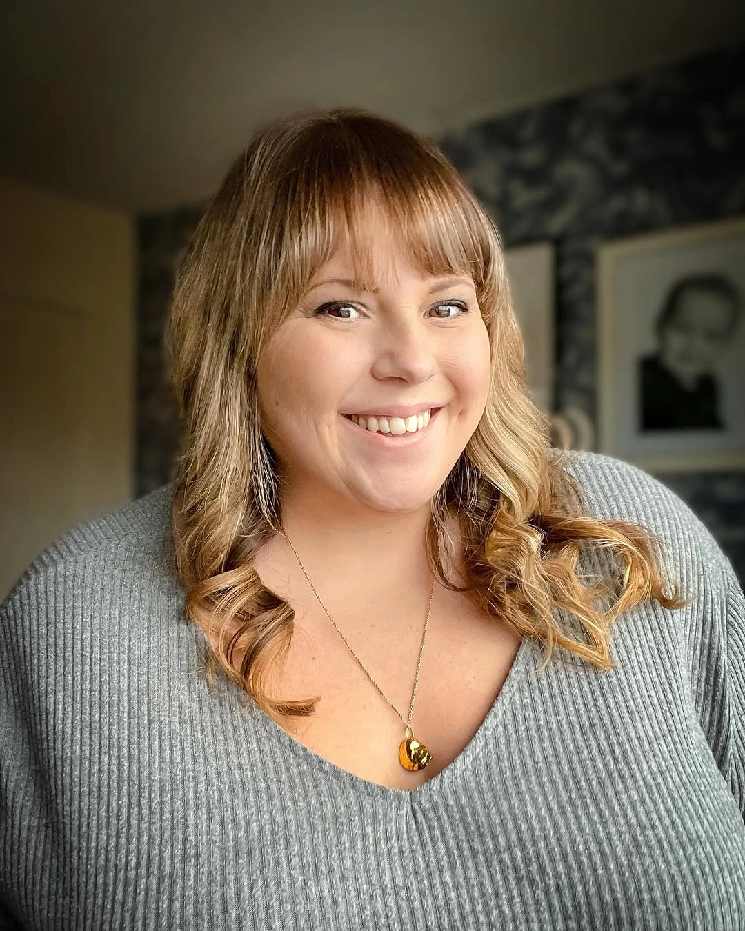 Blonde shoulder-length waves with full bangs and curled ends