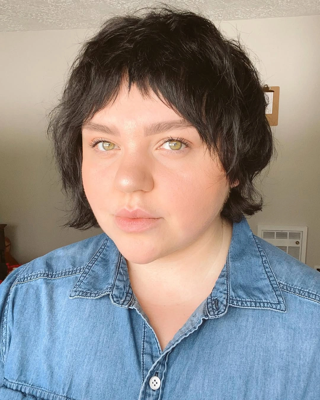 Short dark layered cut with choppy bangs and soft nape pieces