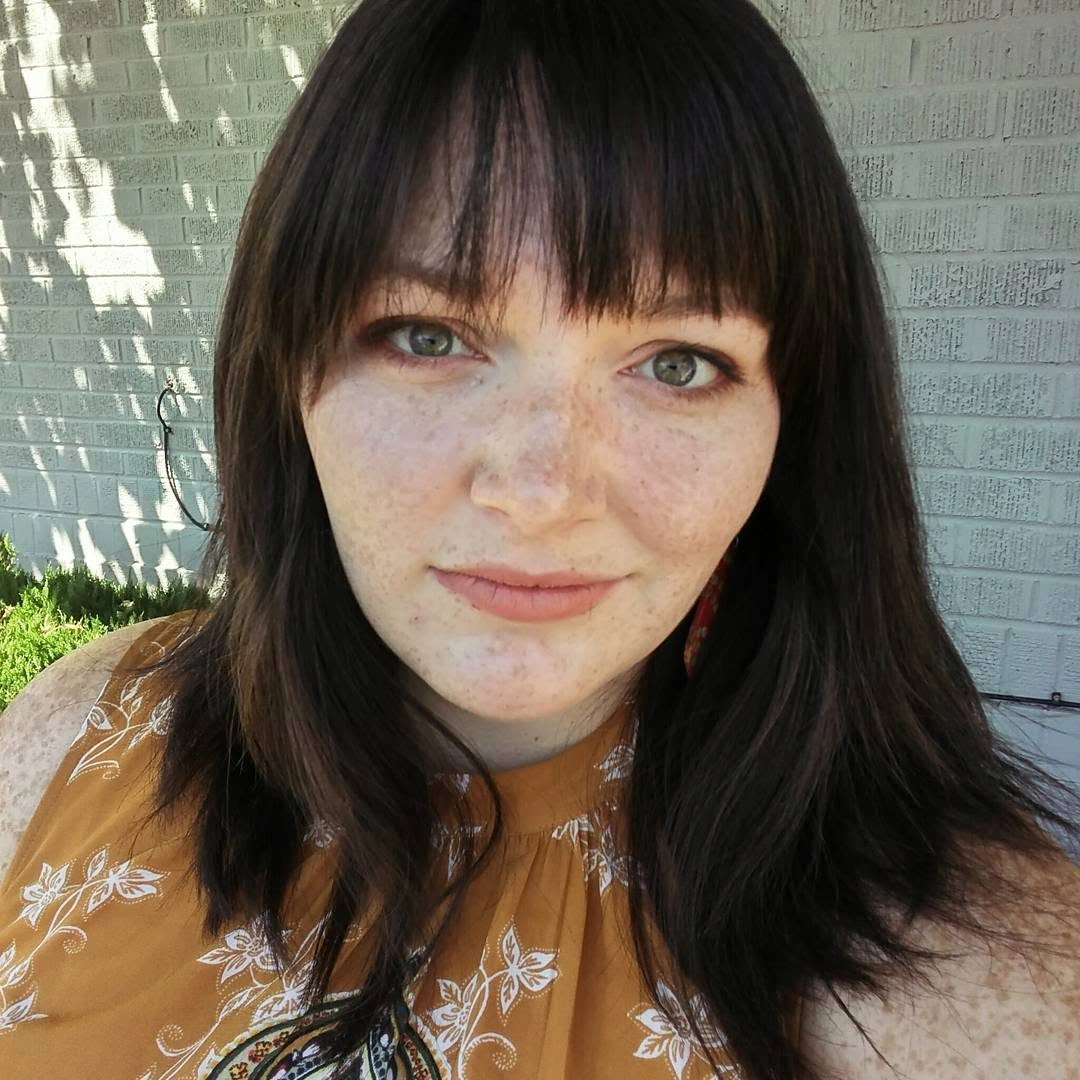 Dark haircut with full bangs and long side lengths