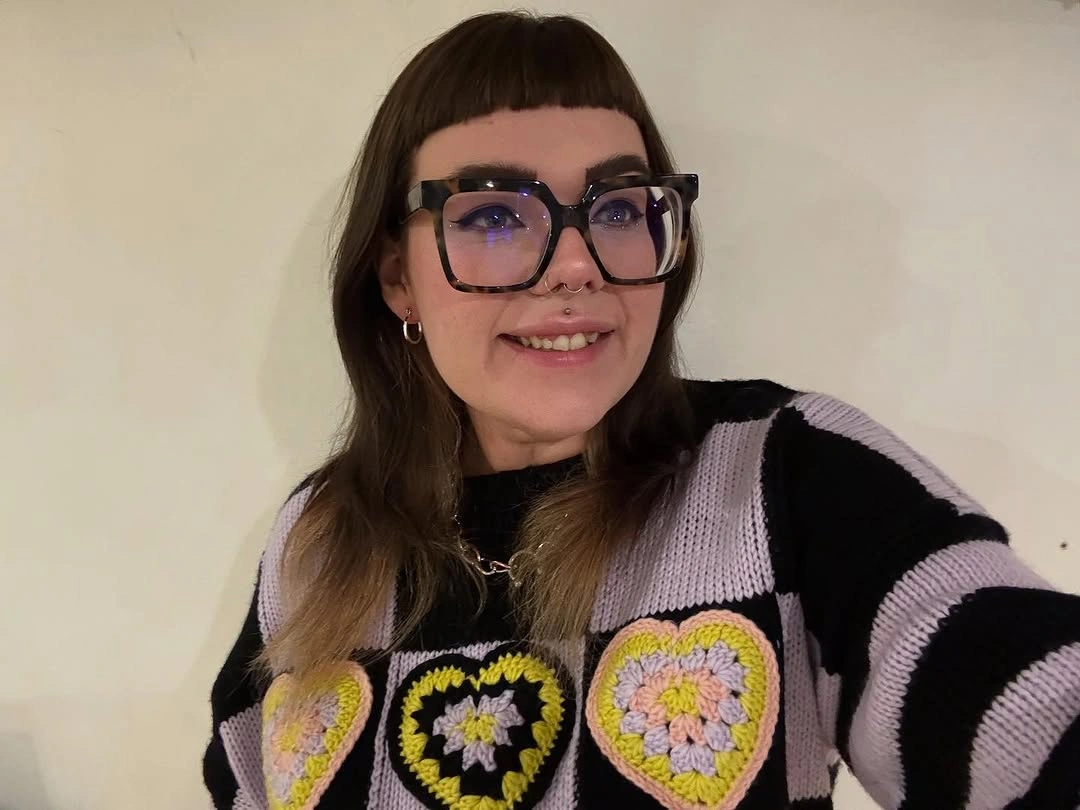 Dark haircut with short bangs, glasses, and lighter ends